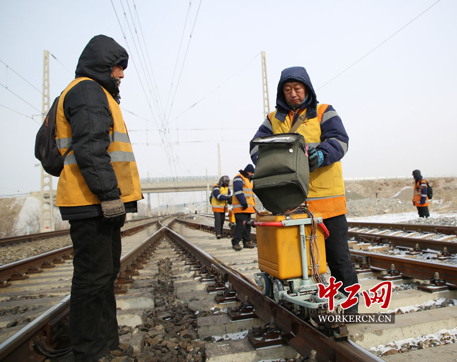 现场防护员石志龙拿着对讲机随时与驻站防护员及远端防护员联系