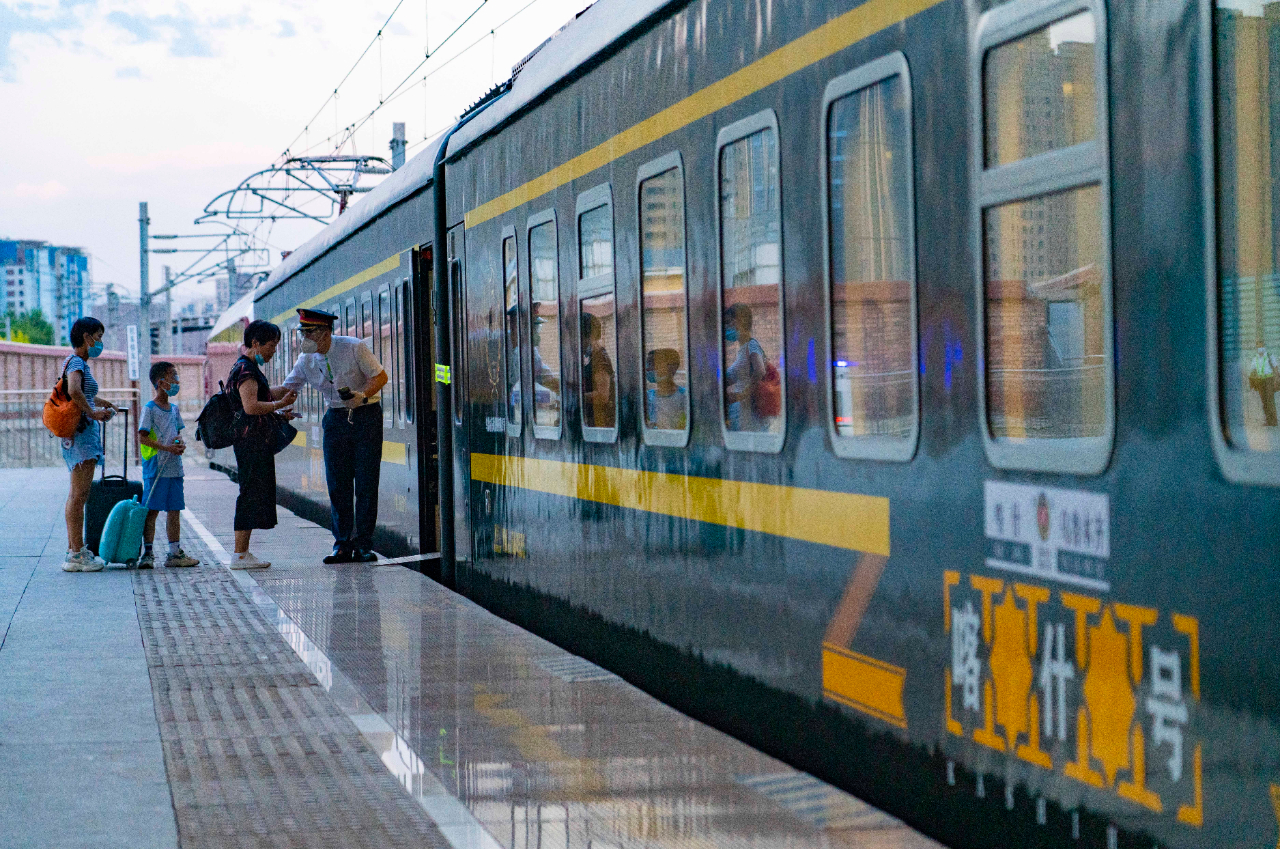 7月24日,喀什号直达特快列车准备发车,乘客在车厢中挥手致意