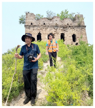 80岁的梅景田（前）还时往往登上长城。